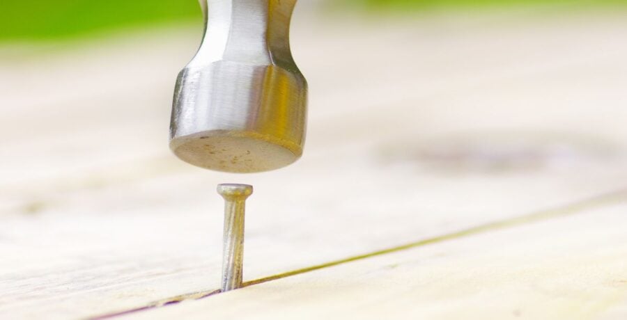 Yellow Hammer Driving Nail into Wood