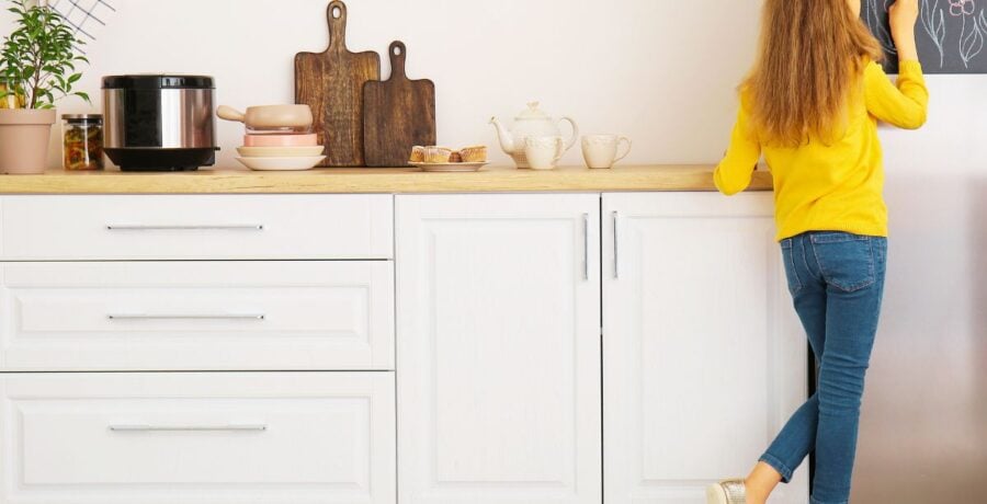 Girl writing on board in a kitchen